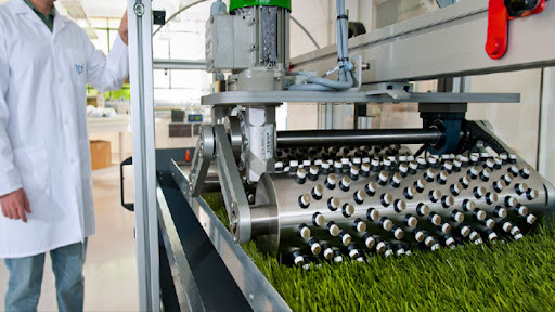 Artificial turf manufacturing machine tufting fibres into backing layer for durable sports turf and landscaping grass performance